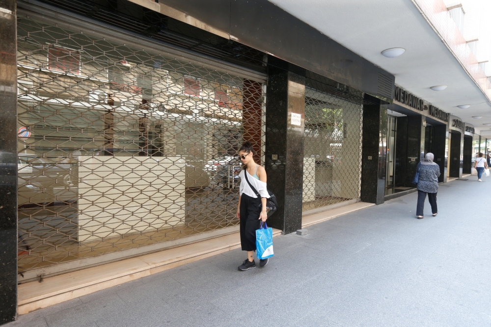 A woman walks past a closed shop in Beirut, Lebanon August 9, 2018. Picture taken August 9, 2018. REUTERS/Mohamed Azakir