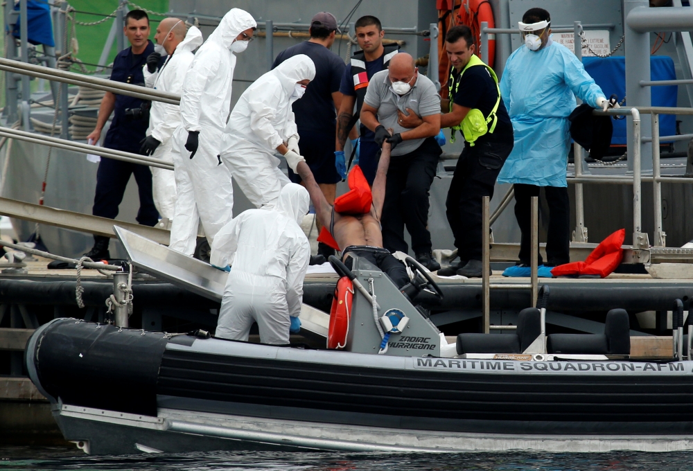 Soldiers carry out the body of a migrant from RHIB, who was found some 68 miles south of Malta by the Armed Forces of Malta maritime squadron and brought on a patrol boat to Marsamxett Harbour, Valletta, Malta August 22, 2018. Reuters/Darrin Zammit Lupi
