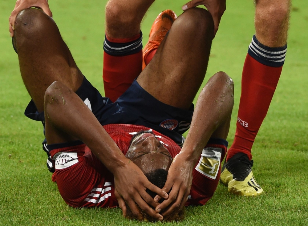 Bayern Munich's German forward Thomas Mueller checks on his injured teammate French forward Kingsley Coman during the German first division Bundesliga football match FC Bayern Munich v TSG 1899 Hoffenheim at the Allianz Arena in Munich, southern Germany o