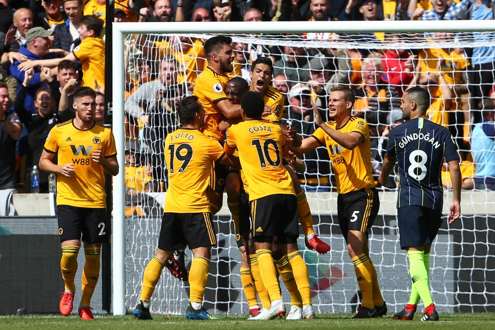 Wolverhampton Wanderers' French defender Willy Boly (C) celebrates with team-mates after scoring the opening goal during the English Premier League football match between Wolverhampton Wanderers and Manchester City at the Molineux stadium in Wolverhampton