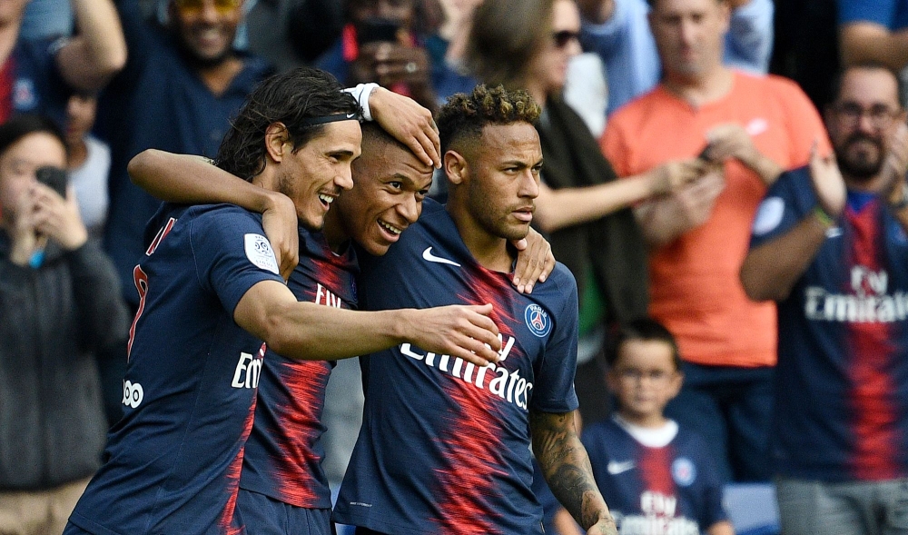 Paris Saint-Germain's French forward Kylian Mbappe (C) is congratulated by Paris Saint-Germain's Brazilian forward Neymar (R) and Paris Saint-Germain's Uruguayan forward Edinson Cavani (L) after scoring a goal during the French L1 football match Paris Sai