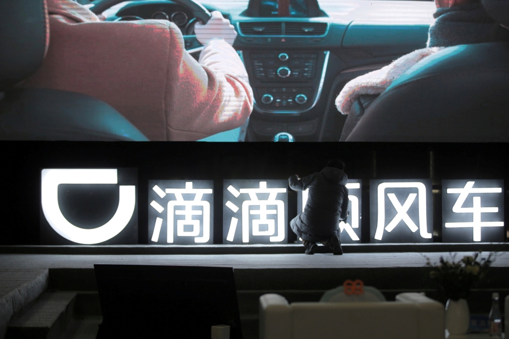 A man is seen in front of a Didi sign before a promotional event of its Hitch service for the Spring festival travel rush, in Beijing, China January 24, 2018. (Reuters/File Photo)
