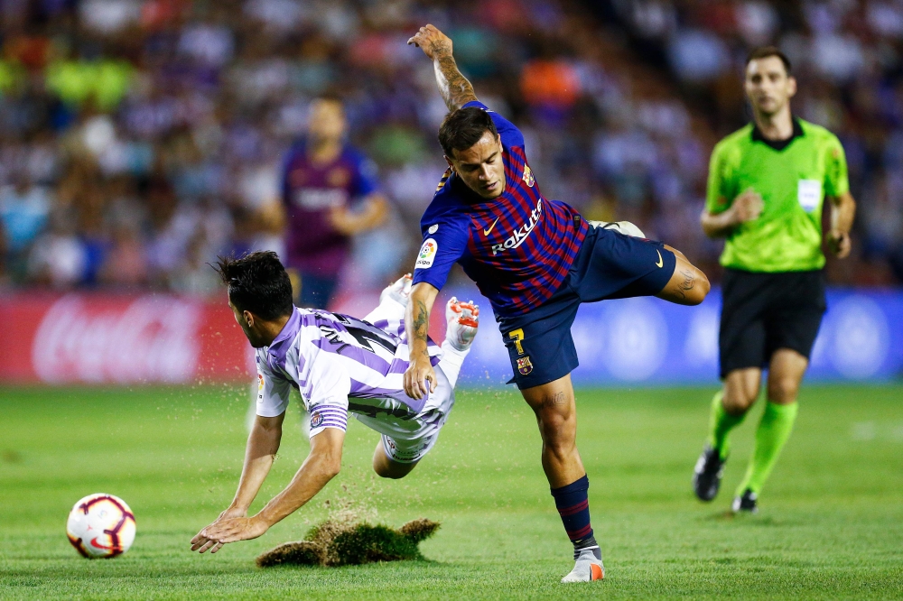 Real Valladolid's Spanish defender Javi Moyano (L) falls beside Barcelona's Brazilian midfielder Philippe Coutinho during the Spanish league football match between Real Valladolid and FC Barcelona at the Jose Zorrilla Stadium in Valladolid on August 25, 2