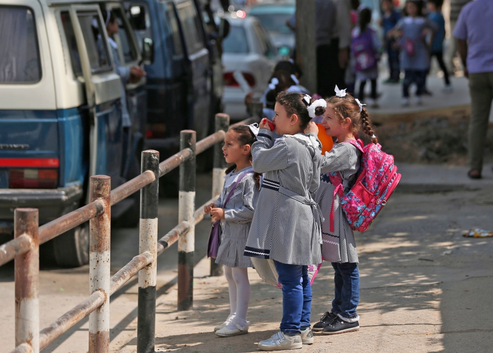 Pupils gather in front of a school run by the United Nations Agency for Palestinian Refugees (UNRWA) in Gaza City on August 29, 2018, on the first day of classes after the summer holidays.  AFP / Mahmud Hams
