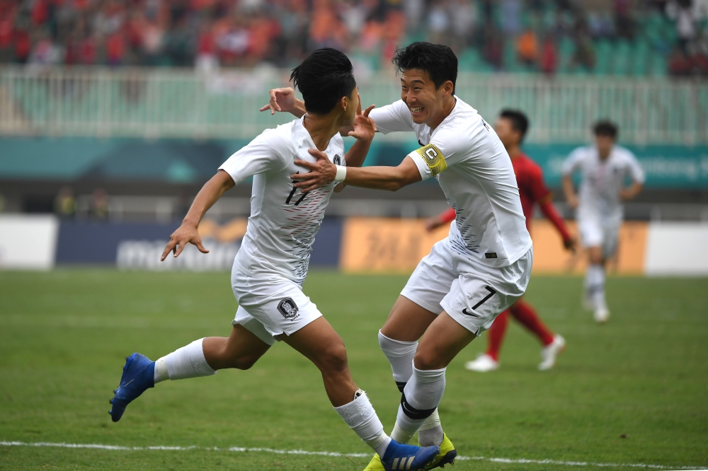 South Korea's Lee Seung-woo (L) celebrates with teammate Son Heung-min (R) after scoring during the men's football semi-final match between Vietnam and South Korea at the 2018 Asian Games in Bogor on August 29, 2018. / AFP / Arief Bagus