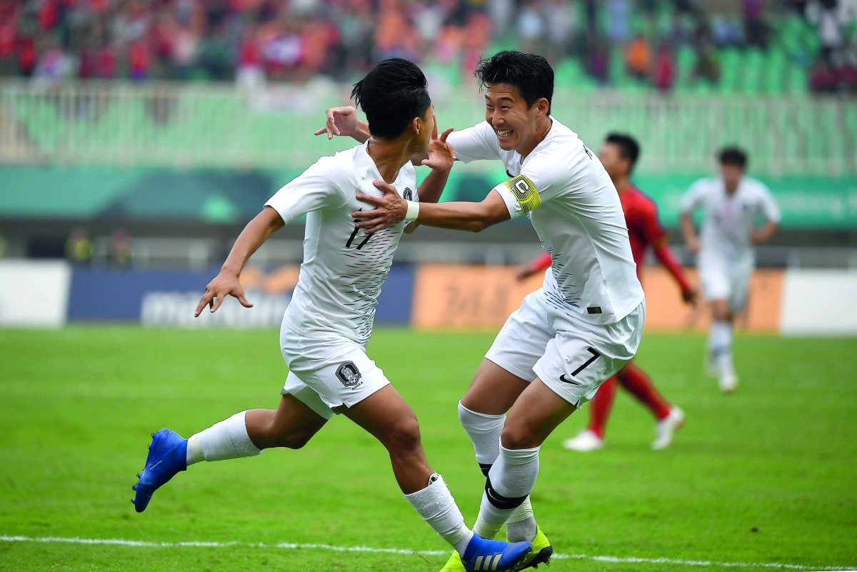 South Korea's Lee Seung-woo (L) celebrates with teammate Son Heung-min (R) after scoring during the men's football semi-final match between Vietnam and South Korea at the 2018 Asian Games in Bogor on August 29, 2018. AFP / Arief Bagus 