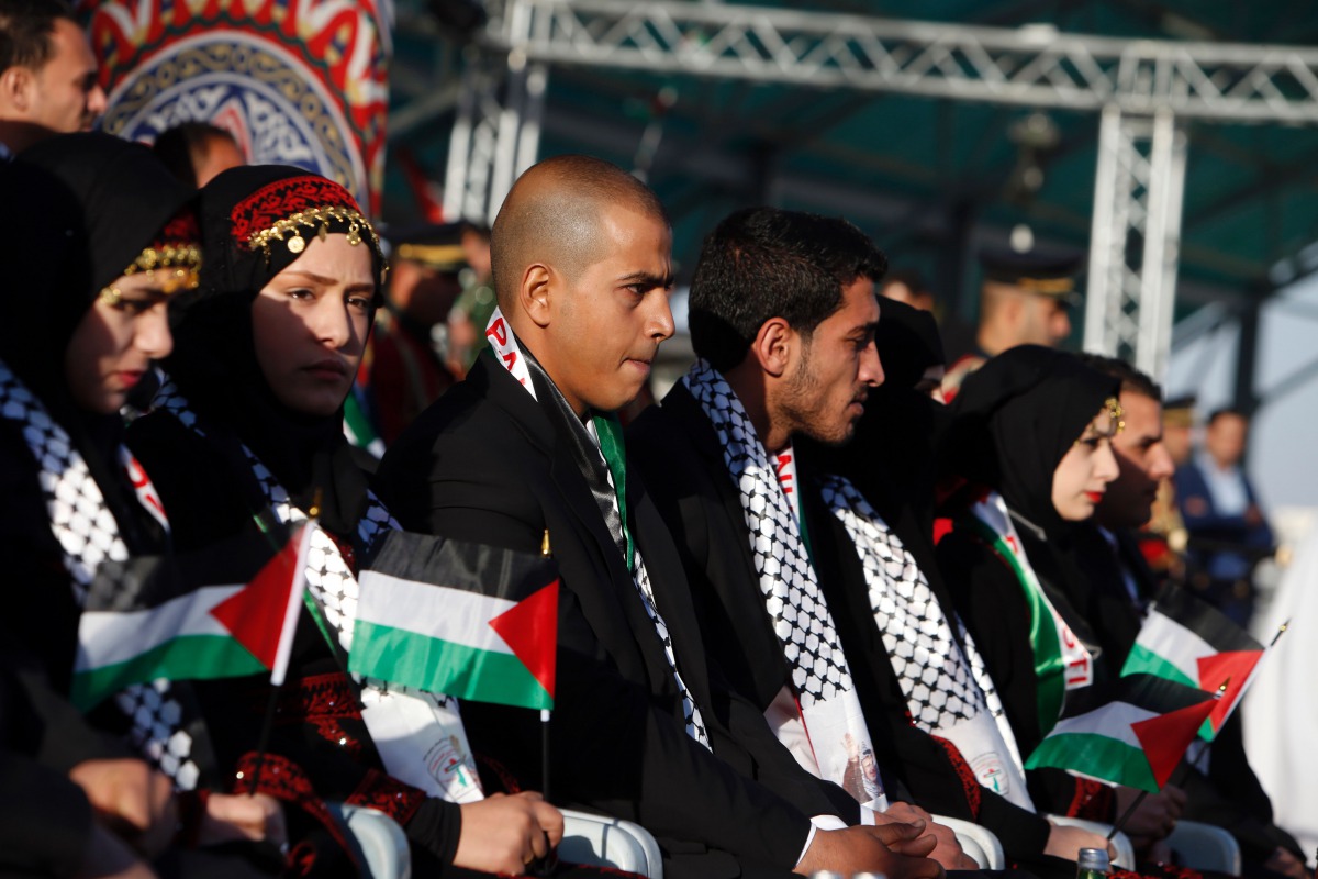 FILE PHOTO: Palestinian couples sit on stage during a group wedding celebration held on November 24, 2016 for 27 couples organised by Fatah movement. AFP / Jaafar Ashtiyeh