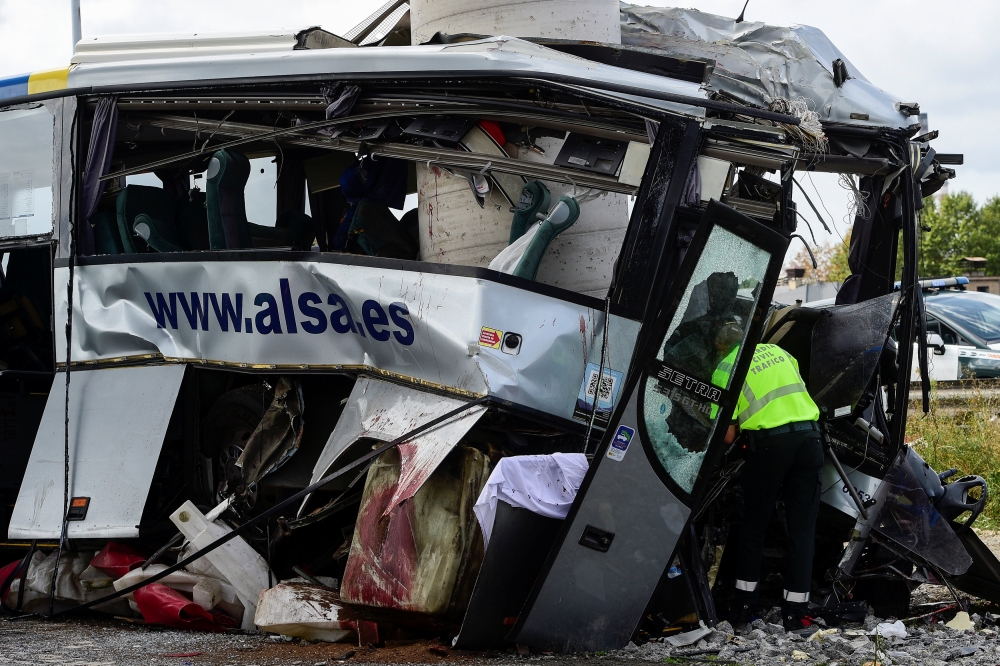 A civil guard surveys the wreckage of a bus crash which left at least four people dead in Aviles, Spain, September 3, 2018. REUTERS/Eloy Alonso