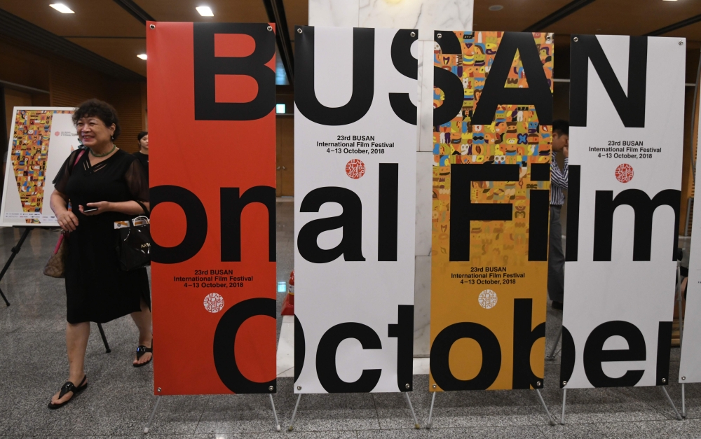 A woman walks past signboards of the Busan International Film Festival (BIFF) after a press conference on the festival overview in Seoul on September 4, 2018. AFP / Jung Yeon-je