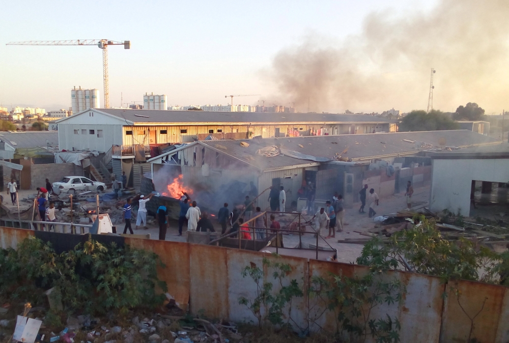 Smoke raise as people check the damaged after a rocket hit a camp for displaced people during the fight between rival armed groups in Tripoli, Libya September 2, 2018. Pictures taken September 2, 2018. REUTERS/Stringer 