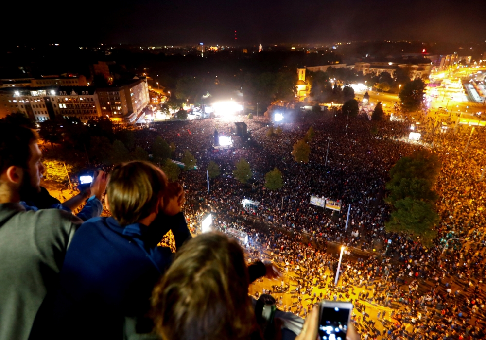 People watch an open-air 