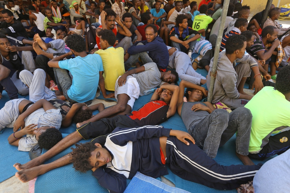 Illegal migrants sit inside the Ganzour shelter after being transferred from in the airport road due to fighting in the Libyan capital Tripoli on September 5, 2018.  AFP / Mahmud TURKIA
