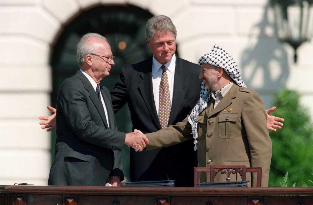  In this file photo taken on September 13, 1993 US President Bill Clinton (C) stands between PLO leader Yasser Arafat (R) and Israeli Prime Minister Yitzahk Rabin (L) as they shake hands for the first time, at the White House in Washington DC, after signi