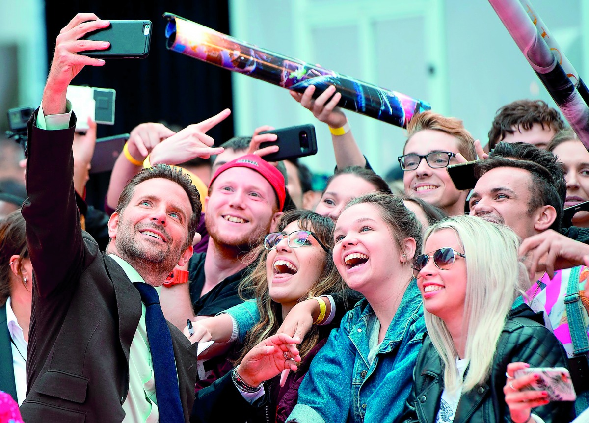 Bradley Cooper takes selfies with fans at the premiere of A Star Is Born during the Toronto International Film Festival, on September 9, 2018, in Toronto, Ontario, Canada. AFP / Valerie Macon
