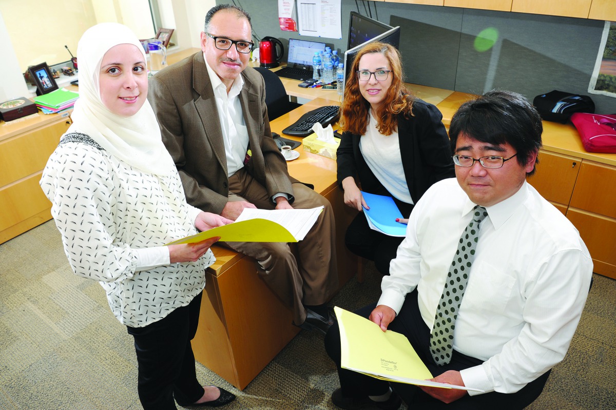 Professor Laith Abu-Raddad (second left) and his team during a discussion. 
