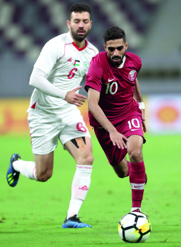 Qatari forward and captain Hasan Al Haydos (right) vies for the ball against Palestine’s Shadi Shaban during their friendly football match played at the Khalifa International Stadium in Doha yesterday. 