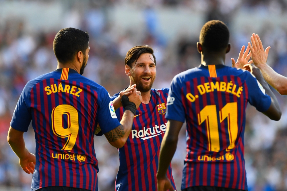 Barcelona's French forward Ousmane Dembele (R) celebrates with Barcelona's Argentinian forward Lionel Messi and Barcelona's Uruguayan forward Luis Suarez after scoring a goal during the Spanish league football match between Real Sociedad and FC Barcelona 