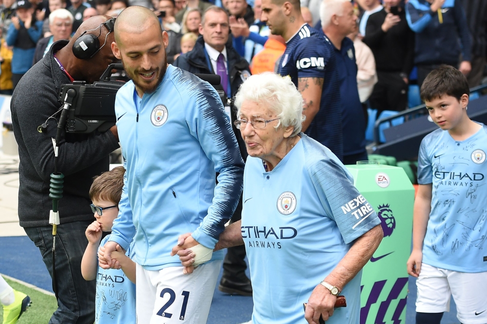 Manchester City's Spanish midfielder David Silva (L) holds the hand of 102-year-old mascot Vera Cohen at the start of the English Premier League football match between Manchester City and Fulham at the Etihad Stadium in Manchester, north west England, on 