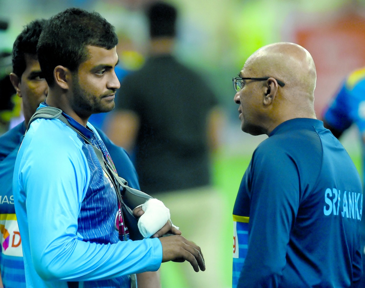 Sri Lankan coach Chandika Hathurusingha (R) talks with Bangladesh's Tamim Iqbal at the end of the one day international (ODI) Asia Cup cricket match between Bangladesh and Sri Lanka at The Dubai International Cricket Stadium on September 15, 2018. AFP / I