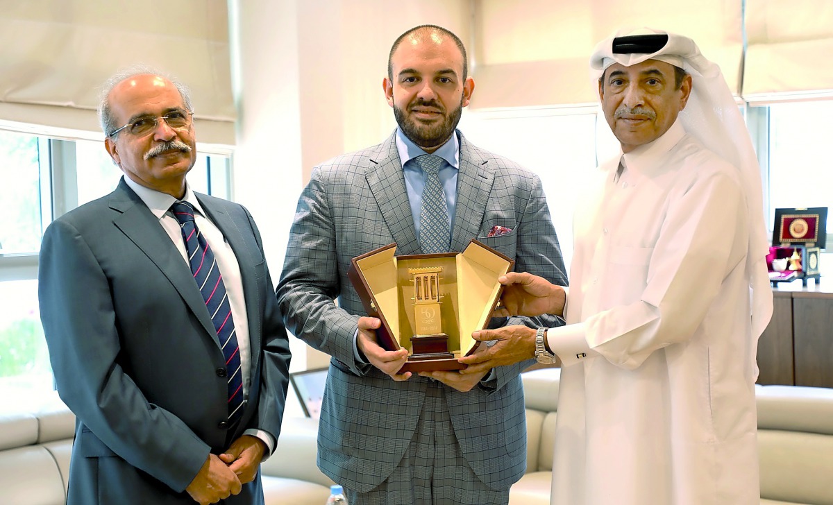 Senior Deputy Group President & CEO of QIC Group,  Ali AlFadala (right), presenting a memento to Ambassador of Romania Cristian Tudor (centre).