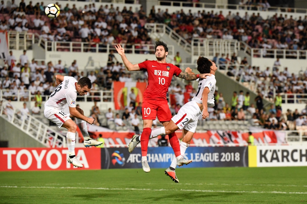 Kashima Antlers' Serginho (L) and Kento Misao (R) compete for the ball with Tianjin Quanjian's Alexandre Pato during the Asian Champions League quarter-final football match between China's Tianjin Quanjian and Japan's Kashima Antlers in Macau on September