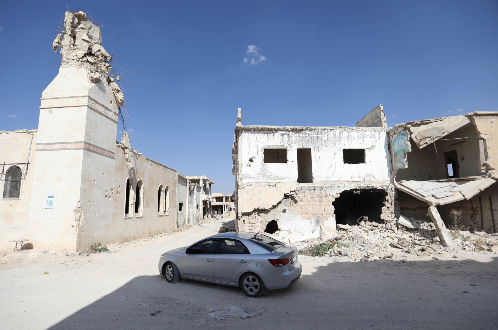 A Syrian motorist drives amidst ruins in Morek, a town in the northern countryside of Hama province that links regime-held areas to the south and rebel territory in neighbouring Idlib province to the north, on September 18, 2018. AFP / OMAR HAJ KADOUR