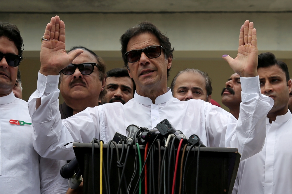 FILE PHOTO: Cricket star-turned-politician Imran Khan, chairman of Pakistan Tehreek-e-Insaf (PTI), speaks to members of media after casting his vote at a polling station during the general election in Islamabad, Pakistan, July 25, 2018. REUTERS/Athit Pera