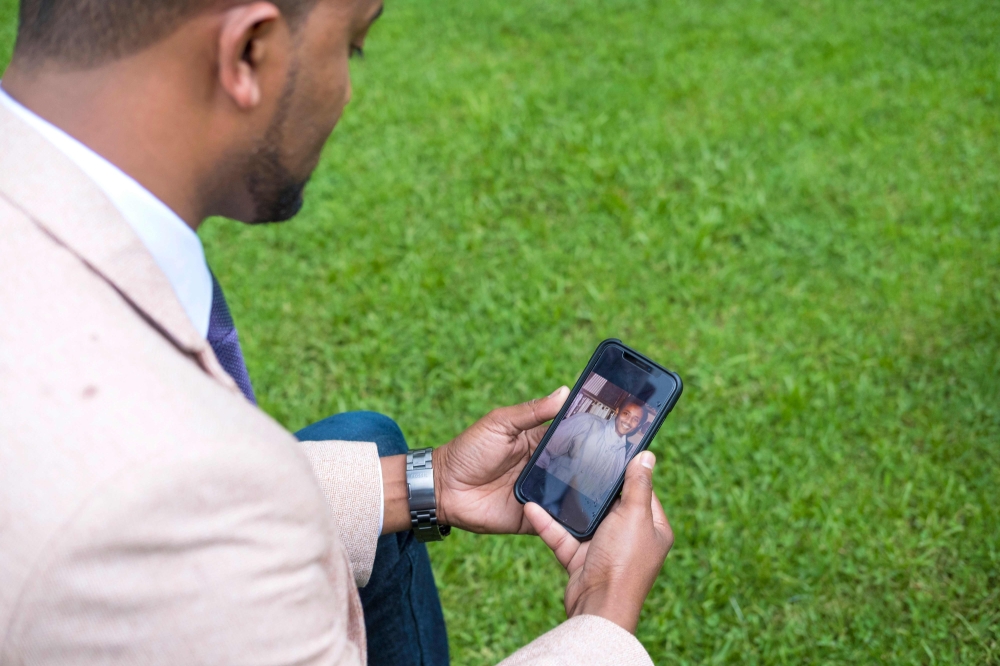 A picture taken on September 4, 2018, shows Ethiopian Edao Dawano who has been searching his father, an official of OLF (Oromo Liberation Front) who was arrested by the government in 1992, looks at this father's image on his mobile phone during an AFP int