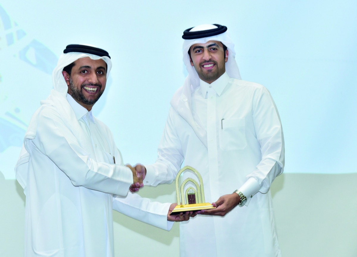 Qatar University President, Dr Hassan Al Derham, honours a QU member at the event. 