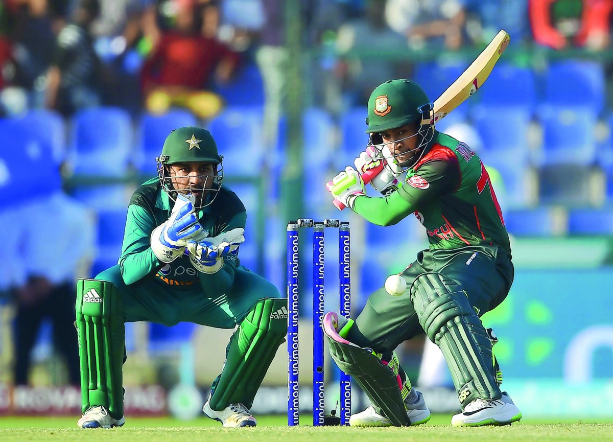 Bangladesh batsman Mushfiqur Rahim plays a shot as Pakistan captain and wicketkeeper Sarfraz Ahmed (L) looks on during the one day international (ODI) Asia Cup cricket match between Bangladesh and Pakistan at the Sheikh Zayed Stadium in Abu Dhabi on Septe