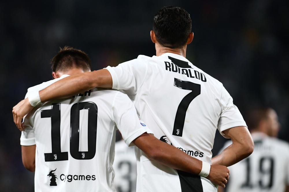 Juventus' Argentinian forward Paulo Dybala (L) celebrates with Juventus' Portuguese forward Cristiano Ronaldo (R) after scoring a goal during the Italian Serie A football match between Juventus and Bologna on September 26, 2018 at the Allianz Stadium in T