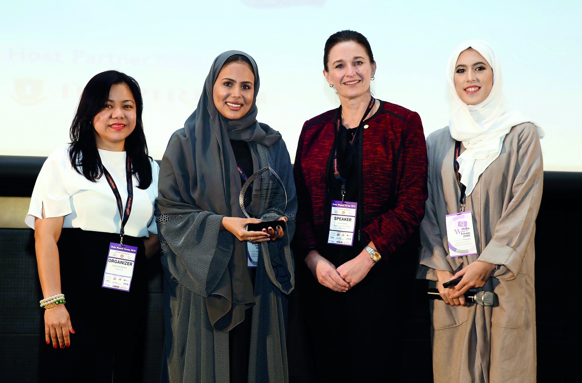Sheikha Asma Al Thani (second left), Director of Marketing and Communications at Qatar Olympic Committee and the keynote speaker at Doha Women Forum 2018, receives an award from Julie Amey (second right), Vice-President of Finance at Qatar Shell, at the W