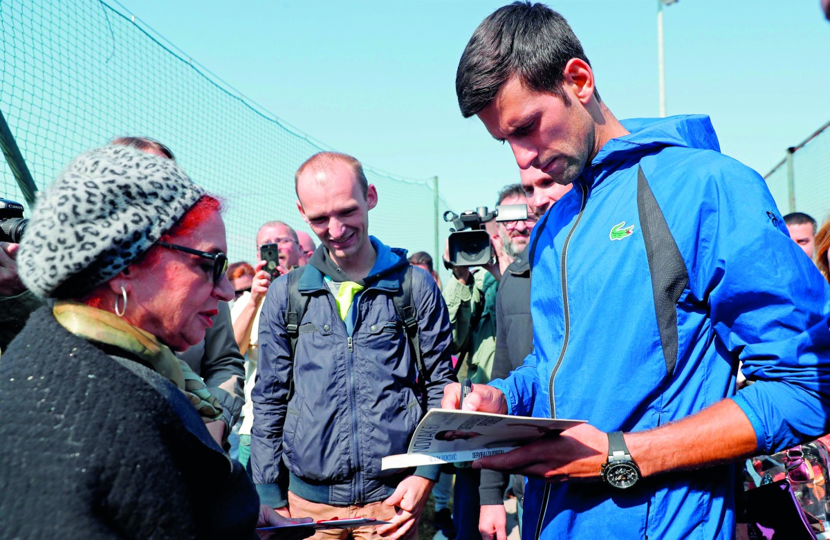 Serbia's tennis player Novak Djokovic signs an autograph after a training session in Belgrade on October 1, 2018. AFP / Pedja Milosavljevic
 