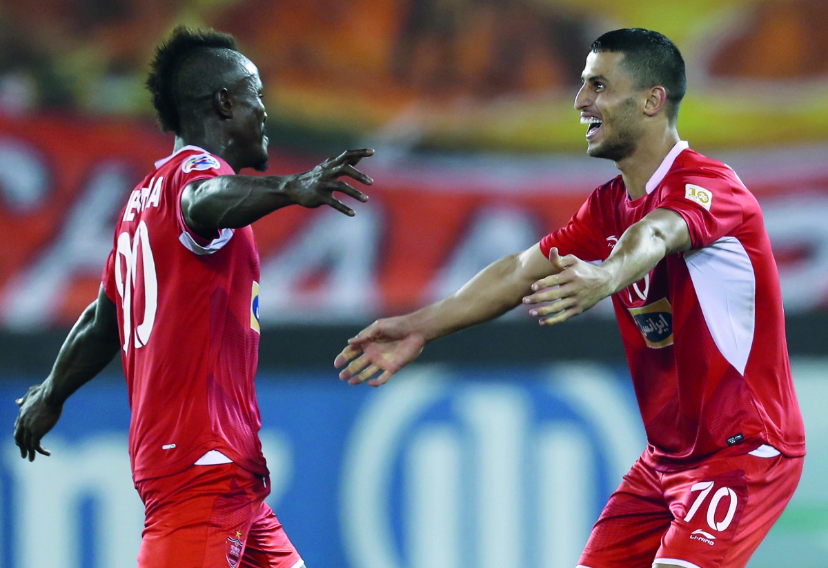 Persepolis’ Ali Alipour (right) celebrates with team-mate Goodwin Mensha after scoring during the AFC Champions League semi-final first leg against Al Sadd at the Jassim Bin Hamad Stadium in Doha, yesterday. 