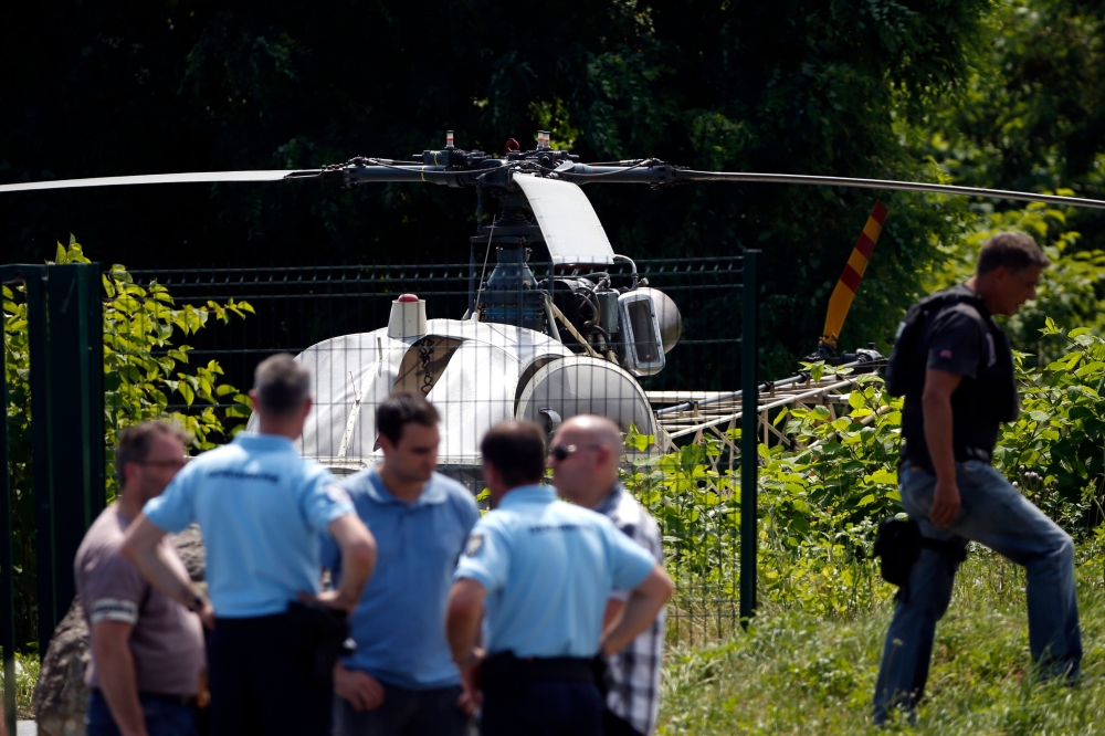 In this file photo taken on July 1, 2018 in Gonesse, north of Paris police patrol near a French helicopter Alouette II abandoned by French armed robber Redoine Faid after his escape from prison in Reau. / AFP / GEOFFROY VAN DER HASSELT