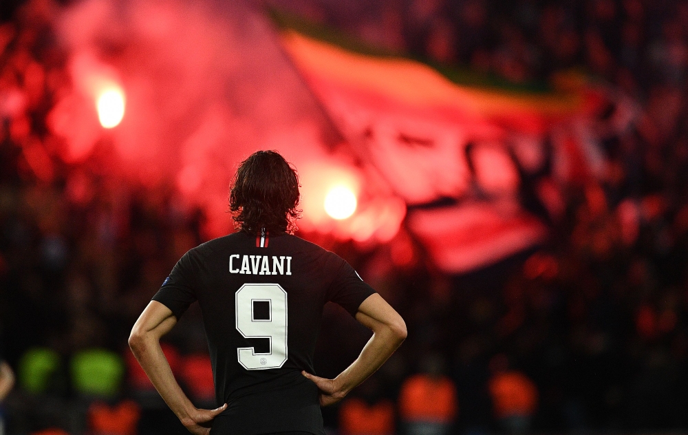 Flares burn as Paris Saint-Germain's Uruguayan forward Edinson Cavani looks on during their UEFA Champions' League football match Paris Saint Germain (PSG) against Red Star Belgrade at the Parc des Princes stadium in Paris on October 3, 2018. / AFP / FRAN