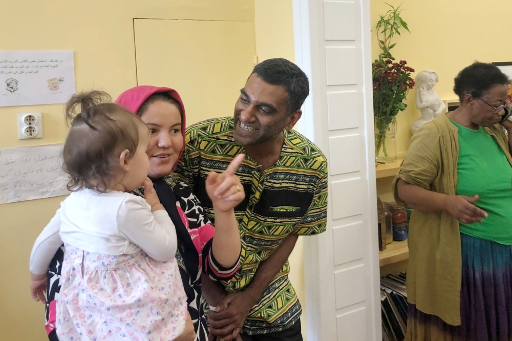 Amnesty International Secretary-General Kumi Naidoo speaks with a refugee woman during his visit to the shelter of the NGO Melissa Network in Athens, Greece, October 5, 2018. Reuters/Karolina Tagaris