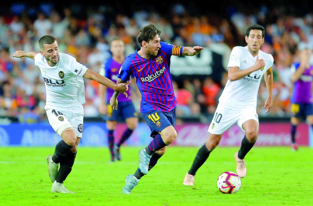 Barcelona's Lionel Messi in action with Valencia's Jose Gaya. Reuters/Heino Kalis