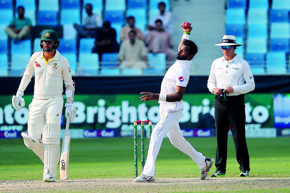 Pakistan cricketer Bilal Asif (C) bowls during the third day of play of the first Test cricket match in the series between Australia and Pakistan at the Dubai International Stadium on October 9, 2018. AFP / Karim Sahib

