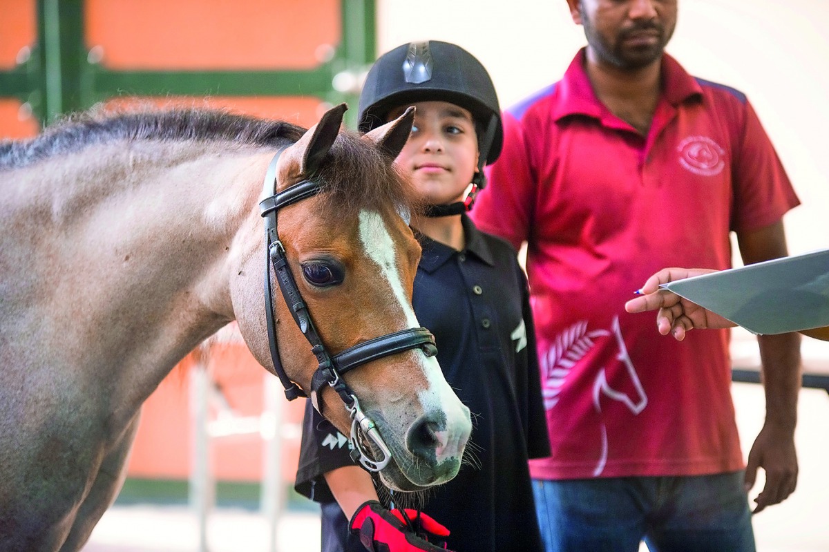 A couple of young riders wait for their turn at Al Shaqab Arena in Doha yesterday. Al Shaqab, one of the top equestrian venues around the world, will welcome the best riders for the final round of the Longines Global Champions Tour next month. 