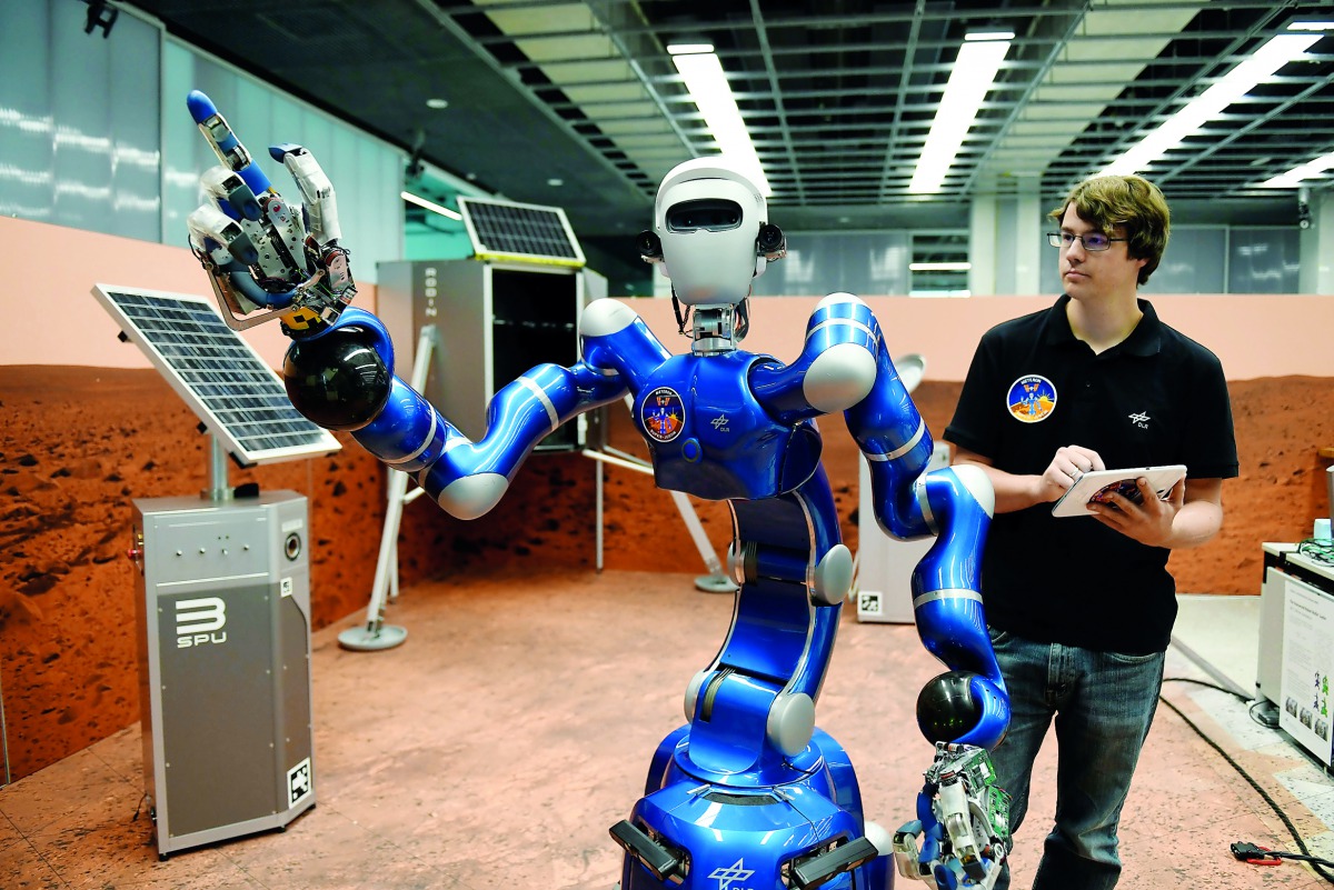An employee makes humanoid robot Justin move his arms in a laboratory at the German Aerospace Center (DLR) in Wessling, near Munich, Germany, October 4, 2018. Reuters/Andreas Gebert