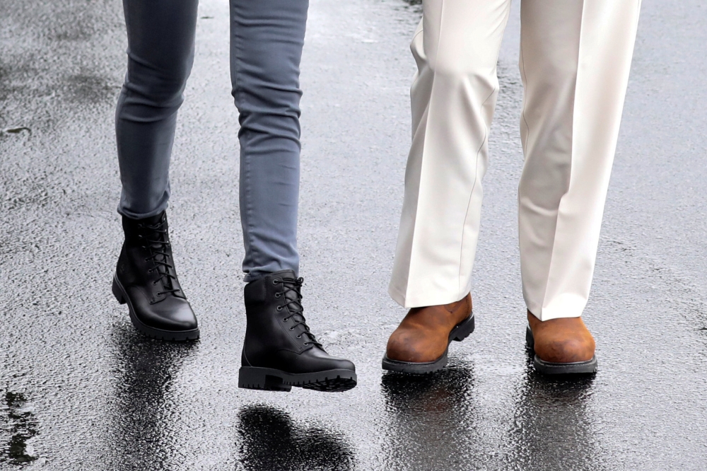 U.S. President Donald Trump and first lady Melania Trump wear boots as they head out together to tour hurricane damage in Florida from the White House in Washington, U.S., October 15, 2018. Reuters/Jonathan Ernst 