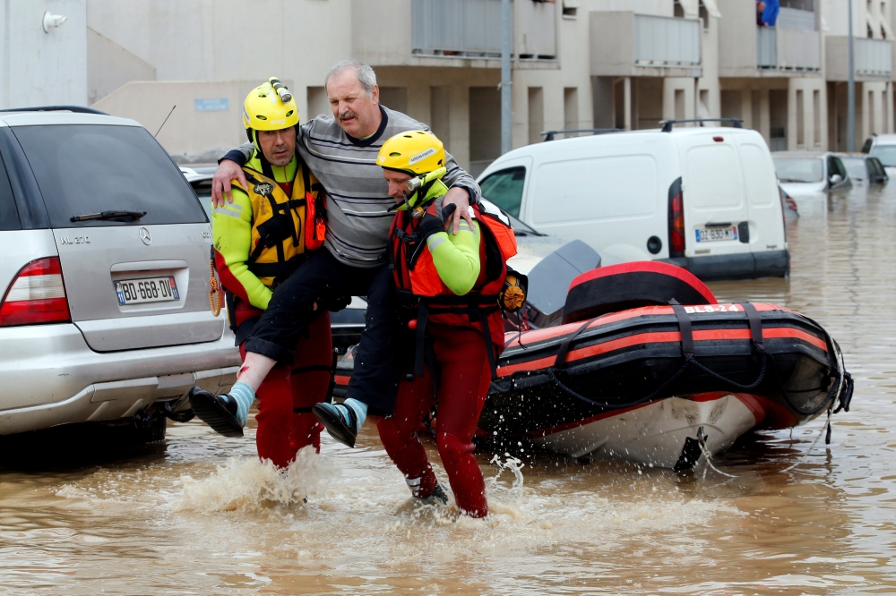 Rescue workers evacuate residents from a neighbourhood after flash floods hit the southwestern Aude district of France after several months' worth of rain fell in just a few hours overnight, in Trebes, France, October 15, 2018. Reuters/Jean-Paul Pelissier