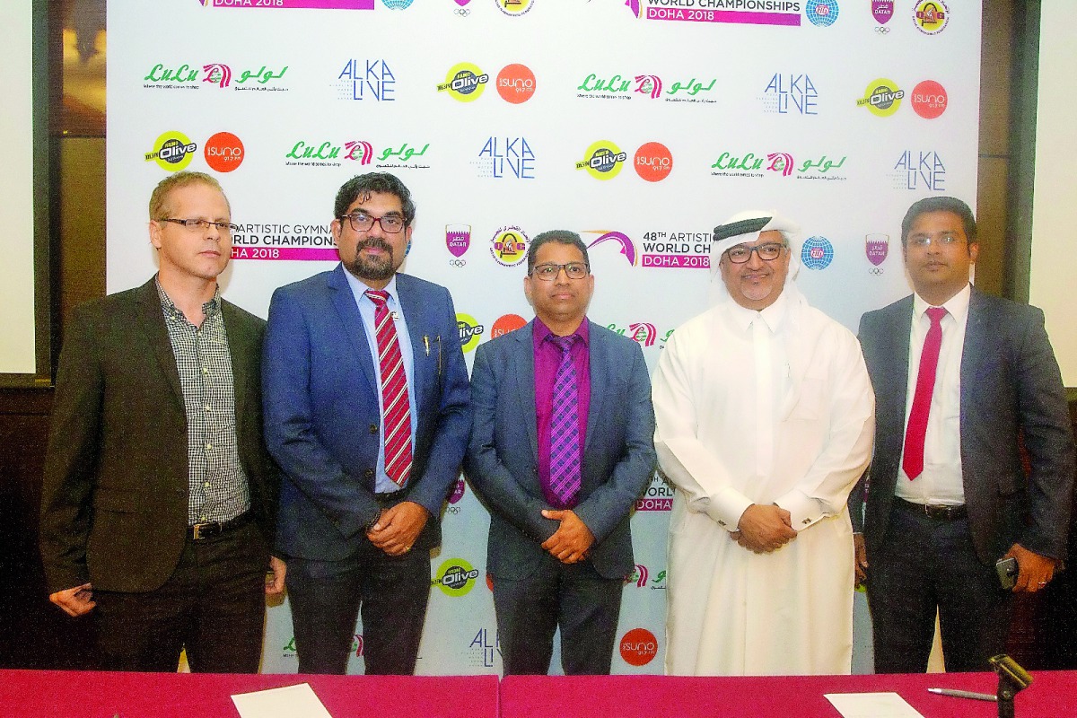 Ali Al Hitmi, Executive Director of the Organizing Committee for the 48th Artistic Gymnastics World Championships Doha 2018 poses for a picture, with the national suppliers and radio partner for the upcoming championship,  after signing agreements in Doha