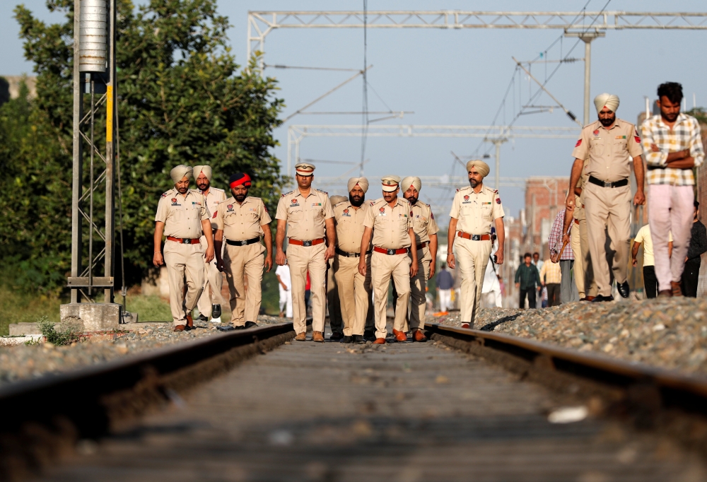 Police patrol along a railway track at the site of an accident after a commuter train traveling at high speed ran through a crowd of people on the rail tracks on Friday, in Amritsar, India, October 20, 2018. REUTERS/Adnan Abidi