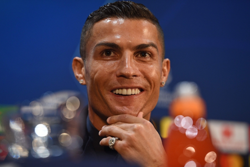 Juventus' Portuguese striker Cristiano Ronaldo smiles during a press conference at Old Trafford in Manchester, north west England on October 22, 2018, on the eve of their UEFA Champions League group H football match against Juventus on October 23. / AFP /