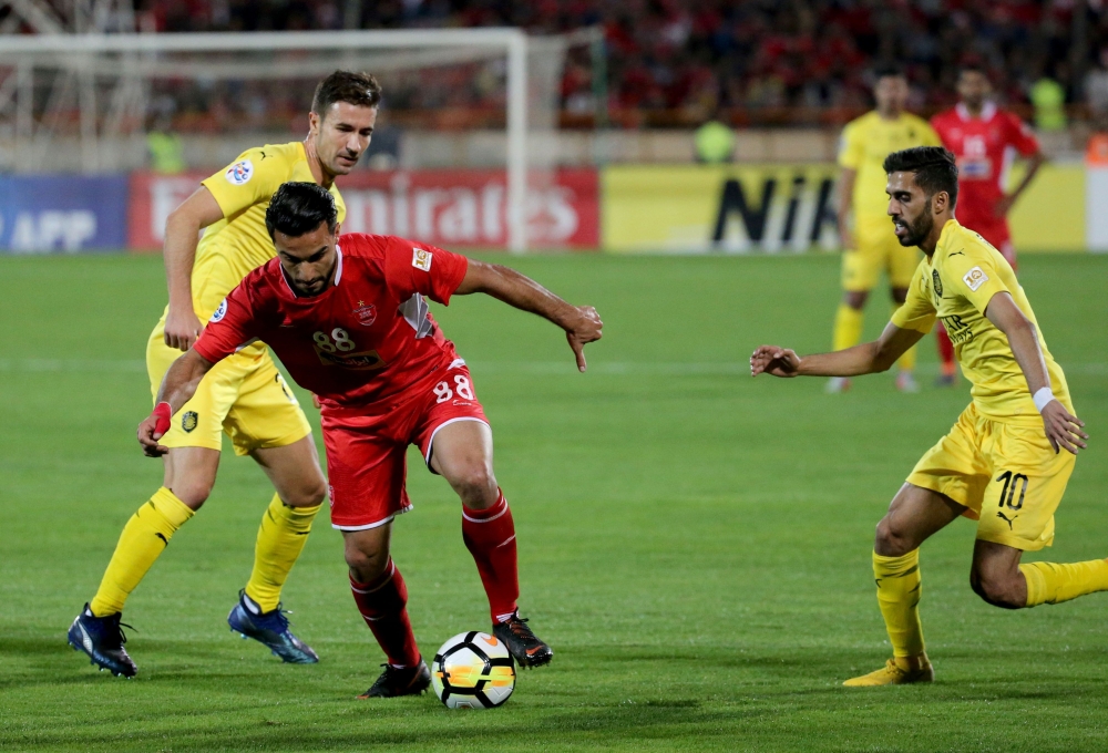 Persepolis' Siamak Nemati (C) fights for the ball with Al-Sadd Gabriel Luis (L) during the AFC Champions League football match Al-Sadd (Qatar) vs Persepolis FC (Iran) at the Azadi Stadium in the Iranian capital Tehran on October 23, 2018. / AFP / ATTA KEN