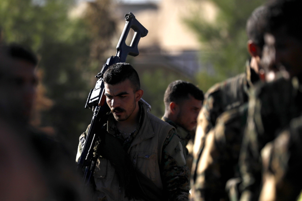Fighters from the Syrian Democratic Forces (SDF) attend the funeral of one of their commanders, killed a day earlier in the town of Hajin during battles against the Islamic State (IS) group, in the Kurdish-controlled city of Qamishly in northeastern Syria