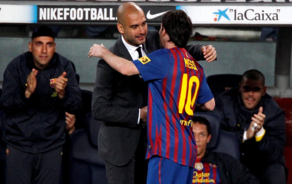 FILE PHOTO: Barcelona's Lionel Messi celebrates his fourth goal with coach Pep Guardiola against Espanyol during their Spanish first division soccer match at Nou Camp stadium in Barcelona May 5, 2012. REUTERS/Gustau Nacarino/File Photo