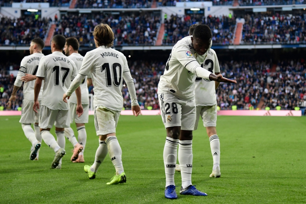 Real Madrid's Brazilian forward Vinicius Junior celebrates Valladolid's own goal during the Spanish league football match between Real Madrid CF and Real Valladolid FC at the Santiago Bernabeu stadium in Madrid on November 3, 2018. / AFP / JAVIER SORIANO
